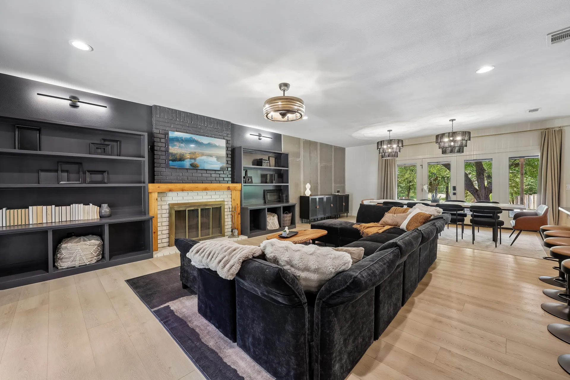 Wild Oak living room with charcoal bookcases, a brick fireplace, and a view through to the dining room